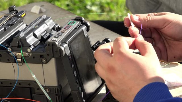 Close-up on the Man hands of the working with Optical fibre communication panel