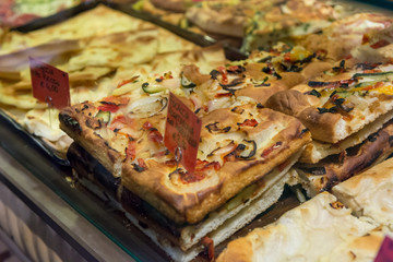 Local bakery selling delicious pizzas and focaccia bread.