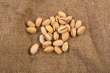 a bunch of pistachios on a cloth from a bag on a white background