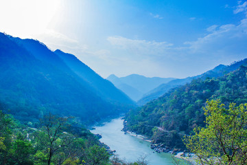 morning top view of Holy Ganges river that flows through Rishikesh passage of mountains looks...