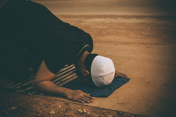 Obraz premium Silhouette Young asian muslim man praying on sunset,Ramadan festival concept