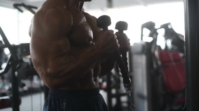 Handsome young fit muscular caucasian man of model appearance workout training in the gym gaining weight pumping up muscle, poses, drinks water  fitness and bodybuilding sport nutrition concept