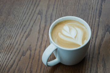 hands holding cups of coffee on rustic wooden table background