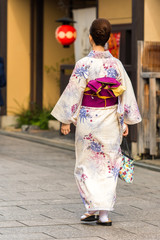 Girl in a kimono on a city street, Kyoto, Japan. Vertical. Copy space for text.