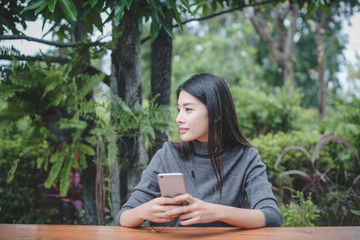 Portrait of young businesswoman use mobile phone while sitting in comfortable coffee shop during work break, charming happy female reading fashion news on cell telephone