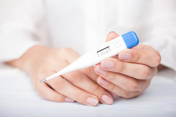 a woman is holding a thermometer