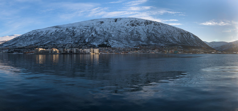Reflections of the mountains in the ice cold water of a fjord around Tromsø, Norway