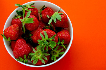 Fresh ripe strawberries in a bowl. Bright background.