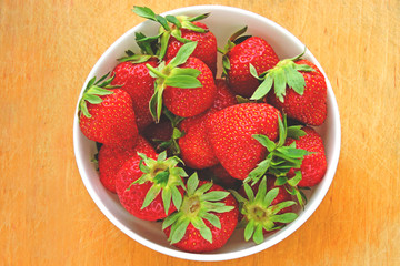 Fresh ripe strawberries in a bowl. Bright background.