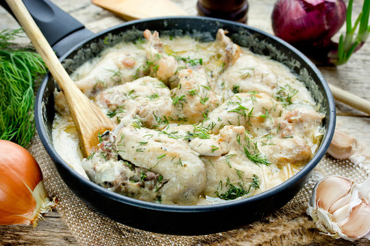 Gedlibzhe — kabardian chicken in sour cream sauce with onion in a frying pan