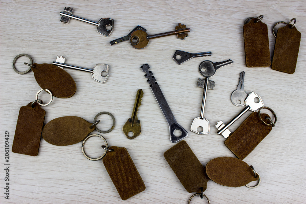 Poster many different keys in oder on wooden background concept
