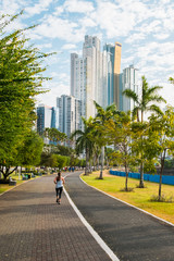 woman running in public park with city skyline in background, Panama city -