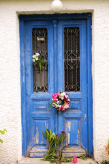 traditionelle alte blaue griechische Tür mit Oleanderkranz