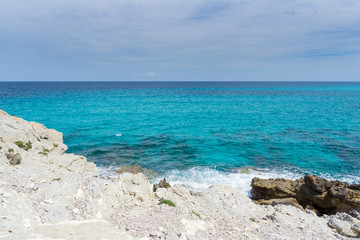 Mallorca, Endless blue horizon of clear sea water at white chalk rock coast with sun