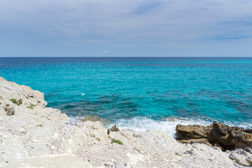 Mallorca, Endless blue horizon of clear sea water at white chalk rock coast with sun
