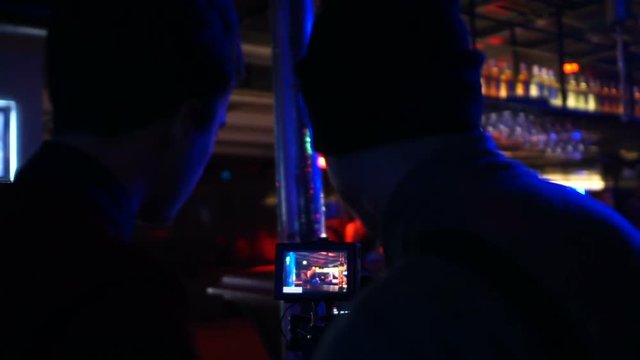 Cameraman and producer filming promotional video of drunk man at night club