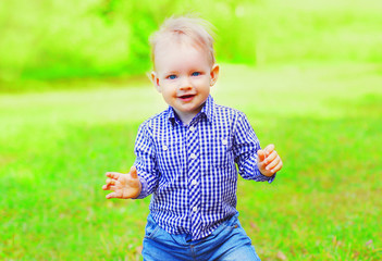 Baby outdoors is having fun on a summer park