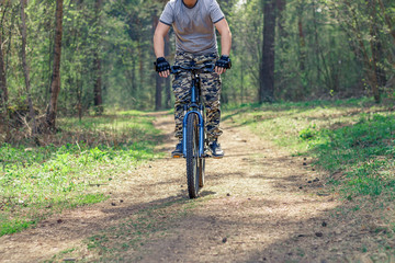 Naklejka premium A man on a bike riding on a forest trail