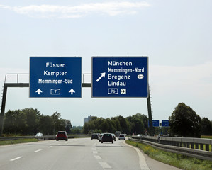 Traffic signs with directions to the city and the state borders
