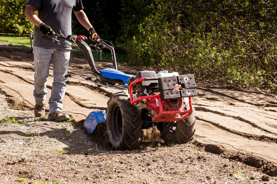rototiller tractor unit preparing soil dirt on outdoor garden