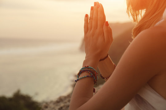 Woman practicing yoga on the beach.