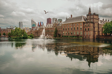 Obraz premium Hofvijver lake with the Binnenhof (Gothic government buildings) and skyscrapers in The Hague. Important political center, is a mix of historic city with modernity. Western Netherlands.