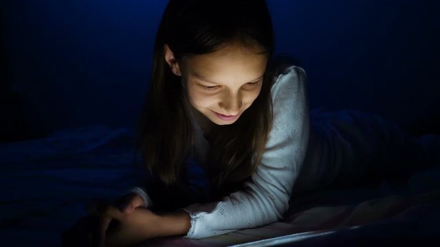 gadget night sleeplessness, caucasian girl chatting playing serfing network, bedtime playing with tablet in bed