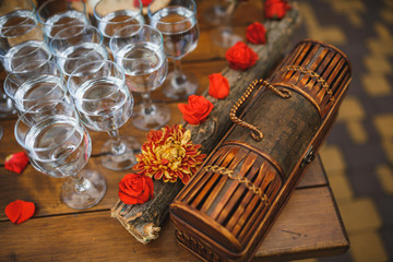 Wedding glasses filled with champagne, water stand on wooden table.