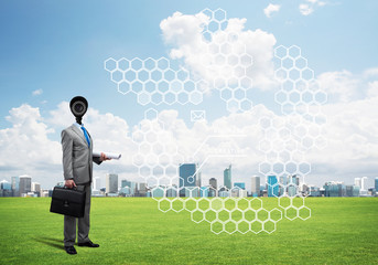 Camera headed man standing on green grass against modern cityscape