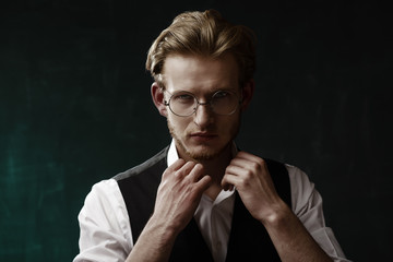 Close up studio portrait of young handsome confident man wearing stylish round glasses