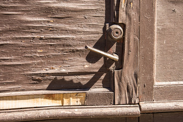 Old door handle door on a peeling wooden door paint.