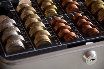 Geldmünzen in einer Geldkassette mit Schloss