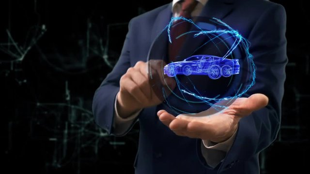 Businessman shows concept hologram Car on his hand. Man in business suit with future technology screen and modern cosmic background