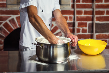 chef making dough for pizza. Man hands preparing bread. Concept of baking and patisserie