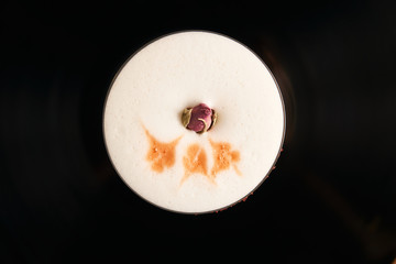 Classical Lucy cocktail on vinyl tray background. Cocktail with Gin, Yogurt, liqueur, Lychee puree, Cardamom syrup, egg white, Lemon juice. Sweet cocktail with spicy taste, close-up