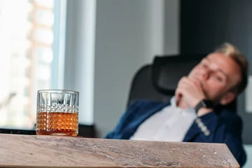 Foto auf Acrylglas Alkohol am Arbeitsplatz. Der Geschäftsmann ruht sich nach der Arbeit aus. © velimir