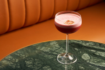 Classical Katana cocktail on table, close-up. Freshly cocktail with Rum, Passionfruit pure, Egg white, Sumax syrup, Ginger infuse. Sour-sweet, light, spicy alcoholic drink