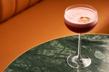 Classical Katana cocktail on table, close-up. Freshly cocktail with Rum, Passionfruit pure, Egg white, Sumax syrup, Ginger infuse. Sour-sweet, light, spicy alcoholic drink