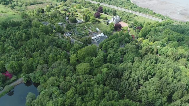Aerial footage over woodland to a large country house and gardens near the village of Langbank on the south shore of the Firth of Clyde.