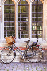 Fototapeta na wymiar Traditional dutch bicycle parked near church window in Amsterdam, vintage style
