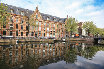 Amsterdam buildings on canal bank with it's reflection, Netherlands.