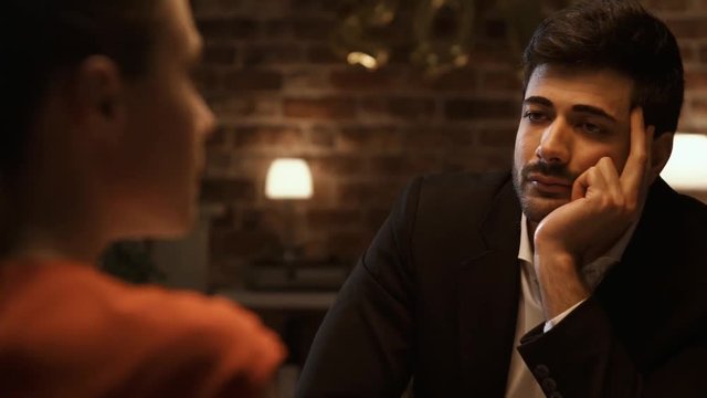 Bored man dining with a talkative chatty woman