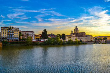 Fototapeta na wymiar Sunset in Arno river with San Frediano in Cestello (Church of Saint Fridianus) at the background, in Florence, Italy.