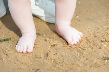 Mother is teaching her baby to do first step