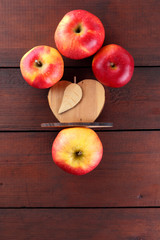 Fruits of oranges and red apples on a dark brown wooden background, halves of oranges on wooden boards. Citrus fruits and apples for vegetarian breakfast
