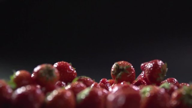 The berries fall on the strawberry in the frame.