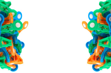 Multi-colored clothespins, located on the right and left of the image on a white background,