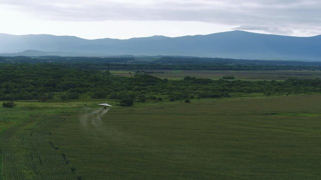AERIAL VIEW from above of a flying paraglider. Beautiful paraplaner on the background of wild nature: rocky mountains, green meadows and plains 4k