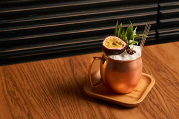 Spicy Mule cocktail on bar table. Alcoholic beverage drink with Rum angostura, reserve rum, dry orange passionfruit ,pure, pineapple pure, spice syrup ingredients, close-up
