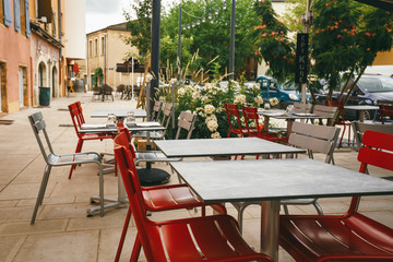 Theme cafes and restaurants. Exterior summer terrace of bright colors of street cafe shop in Europe in France. Preserved tables Without people, at tables nobody.